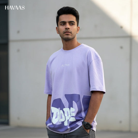 Man wearing a light purple t-shirt with a logo, standing outdoors.